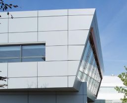 Ein Gebäude mit weißen Metallpaneelen, das modern und minimalistisch wirkt